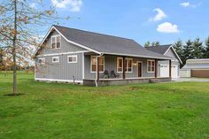 a small gray house sitting on top of a lush green field