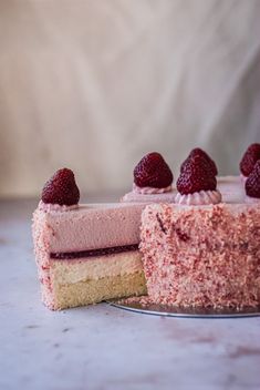 a piece of cake with raspberries on top and one slice missing from it