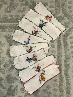 five embroidered napkins are laid out on the floor