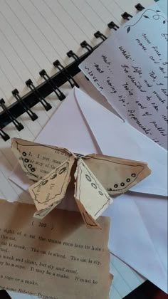 an origami butterfly sitting on top of a piece of paper