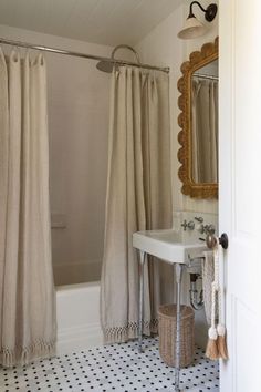 a bathroom with a sink, mirror and shower curtain