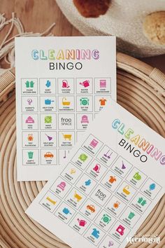 two cleaning bingo cards sitting on top of a wicker basket