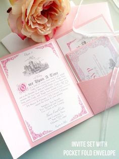 an open pink pocketfold wedding card with a flower on top and the inside of it