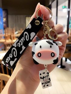 a hand holding a cow shaped key chain