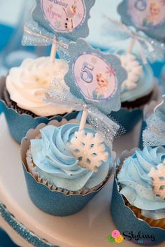 some cupcakes with frosting and decorations on them are sitting on a plate