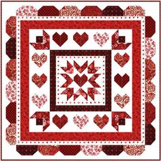 a red and white quilt with hearts in the center, on top of a table