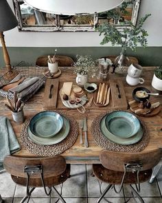 a wooden table topped with plates and bowls