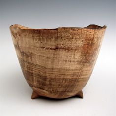 a wooden bowl sitting on top of a white table