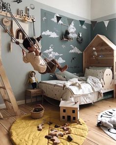 a child's bedroom with a bed, ladder and toys on the floor in front of it