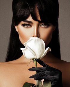 a woman in black gloves holding a white rose