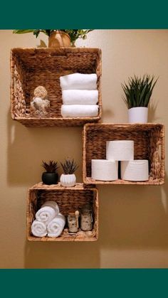 three baskets with towels and other items on them in the corner of a bathroom wall