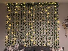 a living room filled with furniture and lots of greenery on the wall behind it