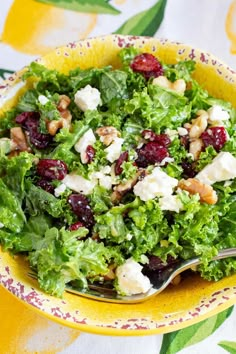 a yellow bowl filled with salad on top of a table