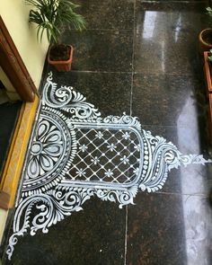 an intricately designed tile floor with potted plants on the side and in front