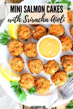 mini salmon cakes with sriraca glaze on a white plate next to lemon wedges and parsley