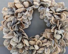 a wreath made out of seashells hanging on a wall