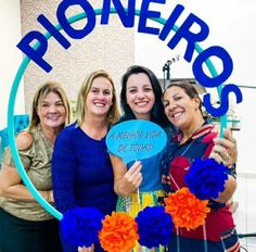 three women standing in front of a sign that says rioneros with flowers on it