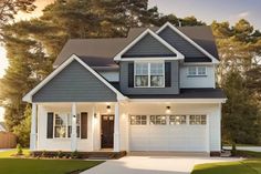 a white and blue house with black shutters in the front yard at sunset or dawn