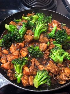 broccoli and chicken are being cooked in a skillet on the stove top