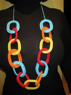 a woman wearing a multicolored necklace on her neck and black shirt behind her