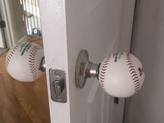 two baseballs are on the door knobs and one is in the shape of a ball