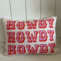 a pillow with the words howdy hodwy on it in red and white