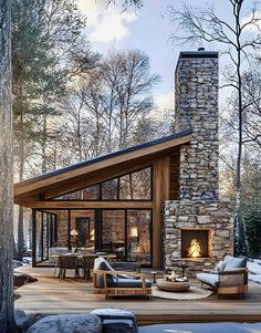 a cabin in the woods with snow on the ground and furniture around it, surrounded by trees