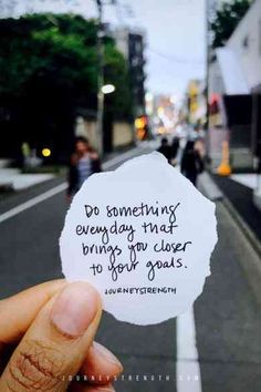 someone holding up a piece of paper that says do something everyday that brings you closer to your goals