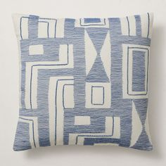 a blue and white pillow sitting on top of a table