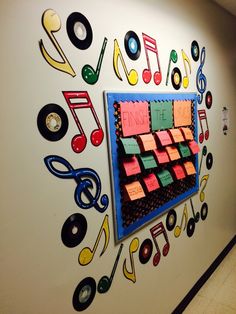 a bulletin board with music notes on it and colorful magnets attached to the wall