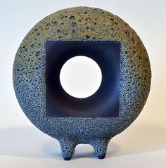 a black and gray vase with a hole in the middle