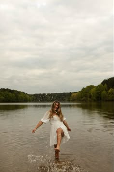 a woman standing in the water with her legs spread out