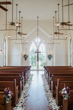 an empty church with pews and flowers on the floor