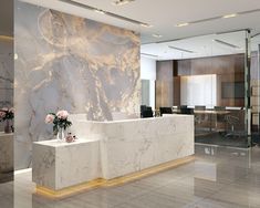 an office with marble walls and flooring, flowers in vases on the counter