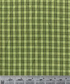 a green and black checkered fabric with a ruler on it's side to show the width