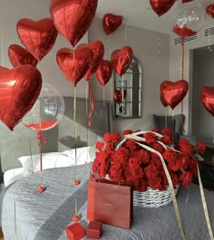 a bed with red roses and heart shaped balloons