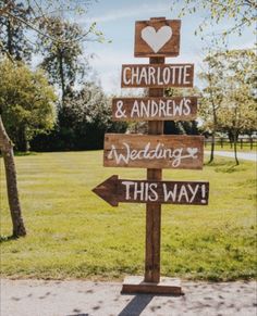 a wooden sign that says charlotte and andrews's wedding this way with hearts on it