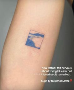 a small blue ink tattoo on the arm