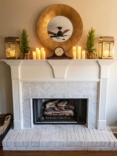 a fireplace with candles and a clock above it