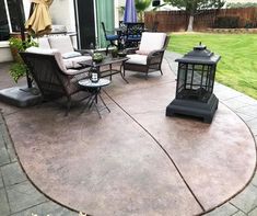 a patio with chairs, tables and an umbrella