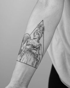 a person with a tattoo on their arm holding an object in one hand and the other