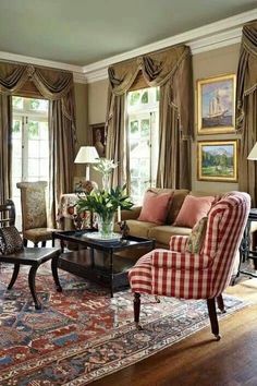 a living room filled with furniture and windows covered in curtained drapes on top of them