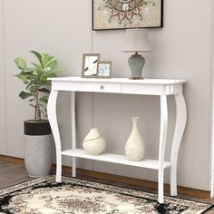 a white console table with two vases on it