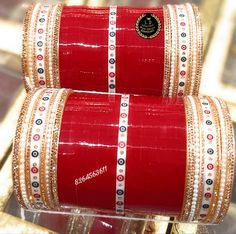 two red and gold bangles sitting on top of each other