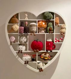 a heart shaped shelf filled with lots of stuffed animals