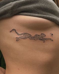 a woman's lower back with a cheetah tattoo on it