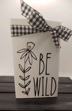 a white box with a black and white bow on it that says, be wild