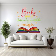 a living room with a white couch and book wall decal