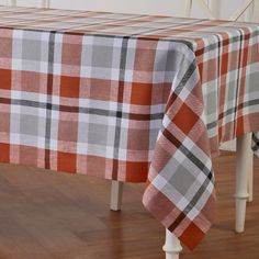 an orange and white checkered table cloth on a dining room table with wood flooring