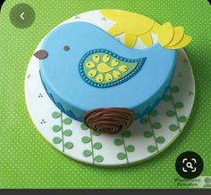 a blue bird cake on a plate with green polka dot tablecloth and wallpaper